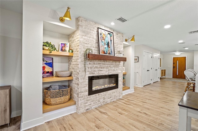 living room with light hardwood / wood-style flooring and a fireplace