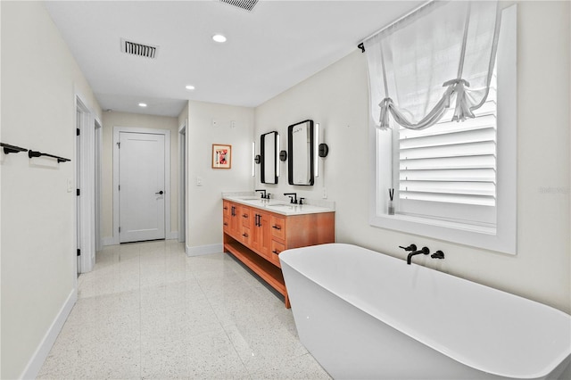 bathroom featuring a tub to relax in and vanity