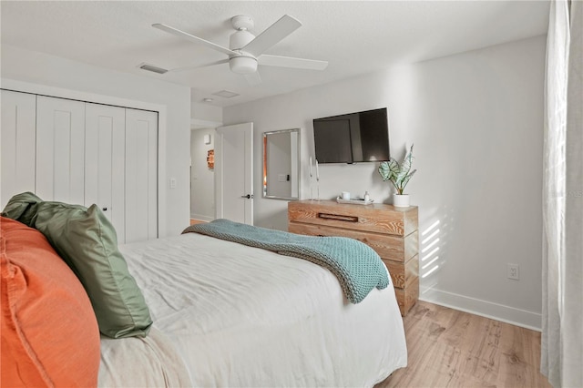 bedroom with ceiling fan, a closet, and light hardwood / wood-style floors