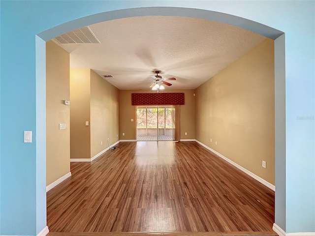 unfurnished room featuring ceiling fan, hardwood / wood-style floors, and a textured ceiling