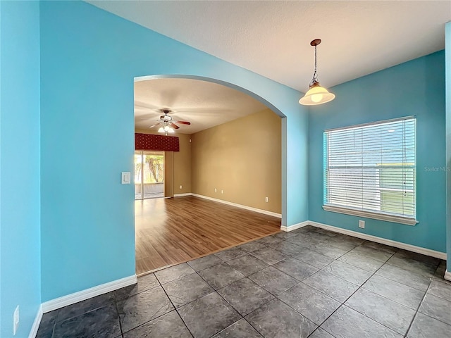 tiled spare room featuring ceiling fan