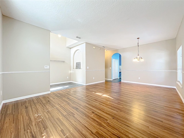 interior space with hardwood / wood-style flooring, a textured ceiling, and a notable chandelier