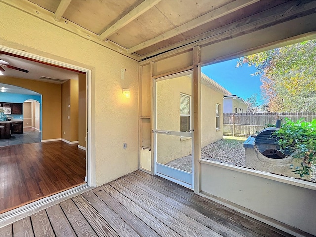 unfurnished sunroom featuring ceiling fan