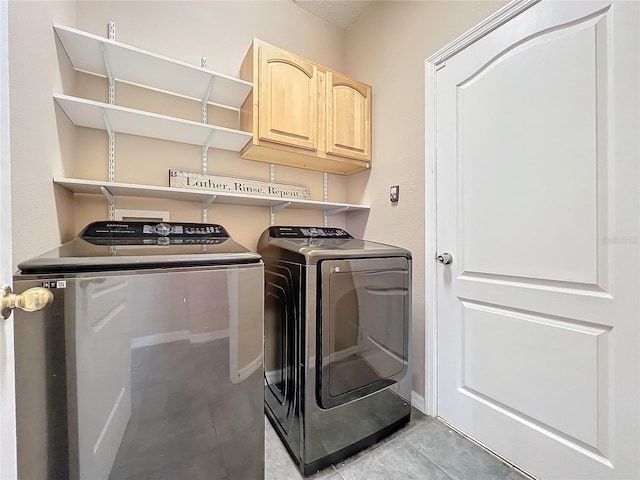 washroom featuring cabinets and independent washer and dryer