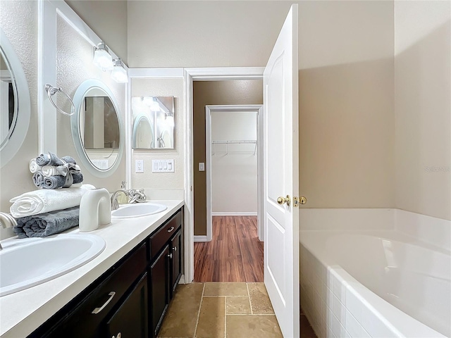 bathroom with a washtub and vanity