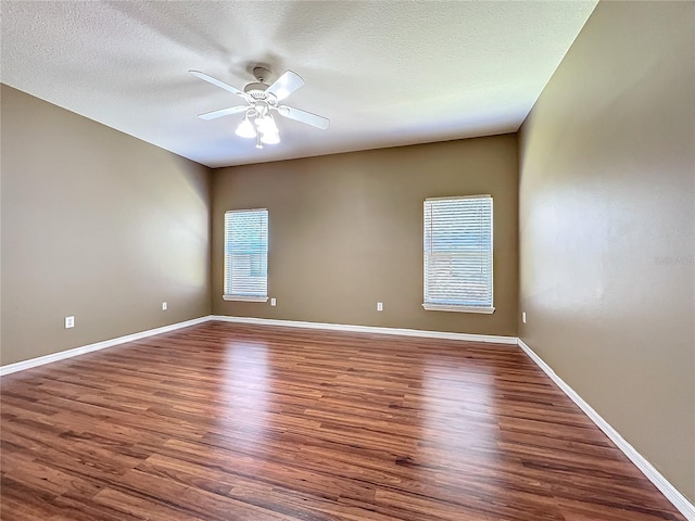 unfurnished room with ceiling fan, dark hardwood / wood-style flooring, and a textured ceiling