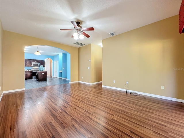 unfurnished living room with a textured ceiling, light hardwood / wood-style flooring, and ceiling fan