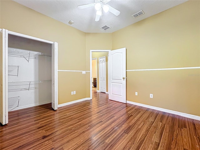 unfurnished bedroom featuring ceiling fan, wood-type flooring, a textured ceiling, and a closet