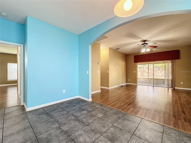 tiled spare room featuring ceiling fan