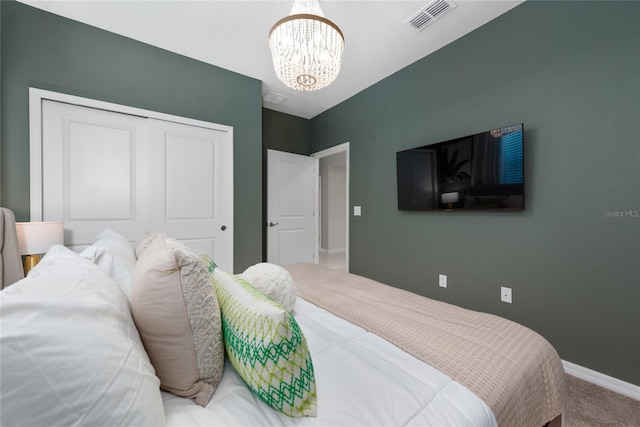 carpeted bedroom featuring an inviting chandelier and a closet