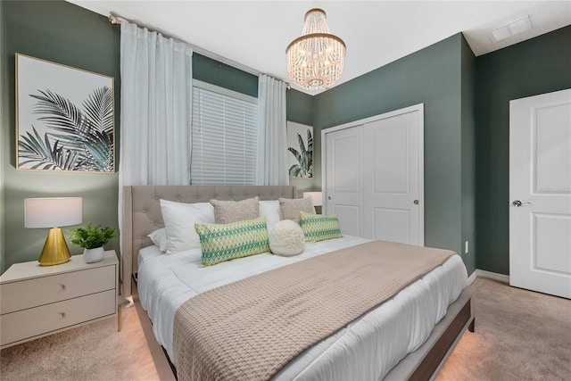 carpeted bedroom featuring an inviting chandelier and a closet