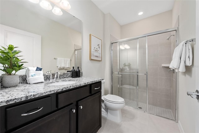 bathroom featuring tile patterned flooring, a shower with door, vanity, and toilet