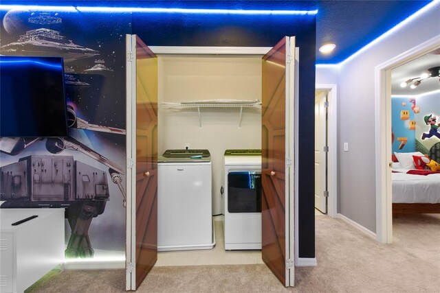 laundry area with independent washer and dryer and light colored carpet