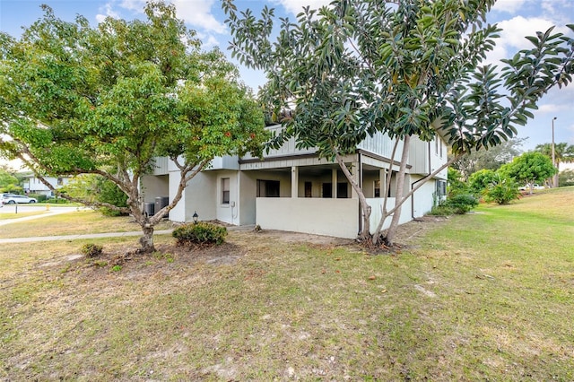 view of front of property featuring a front yard and central AC unit