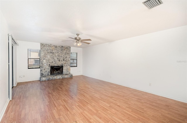 unfurnished living room featuring ceiling fan, light hardwood / wood-style floors, and a fireplace