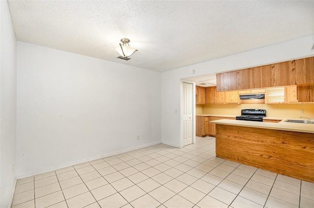 kitchen with a textured ceiling, kitchen peninsula, black range oven, and light tile patterned floors