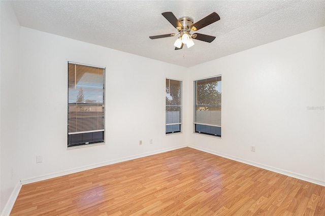 unfurnished room with ceiling fan, a textured ceiling, and light wood-type flooring