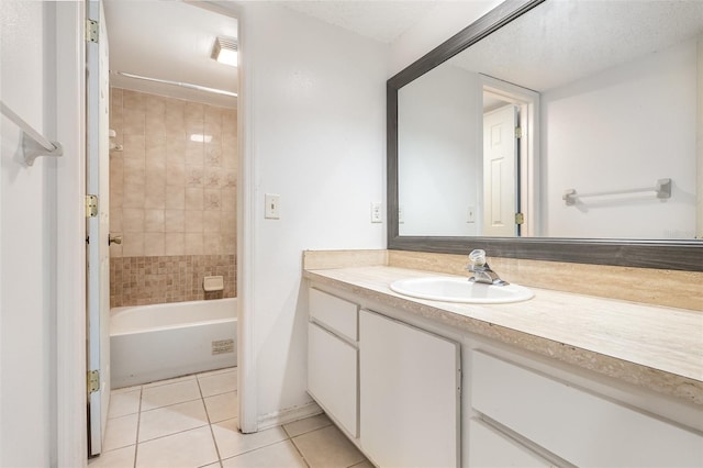 bathroom with tile patterned flooring, tiled shower / bath combo, a textured ceiling, and vanity