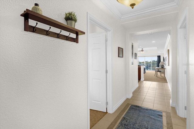 hall with light tile patterned floors and crown molding