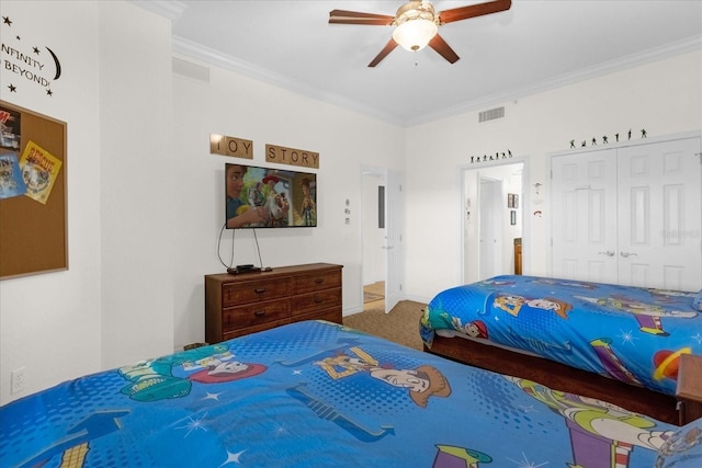 bedroom with ceiling fan, ornamental molding, carpet floors, and a closet