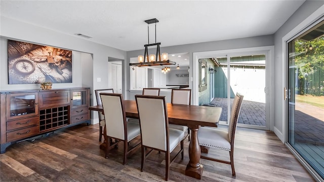 dining area featuring a notable chandelier and dark wood-type flooring