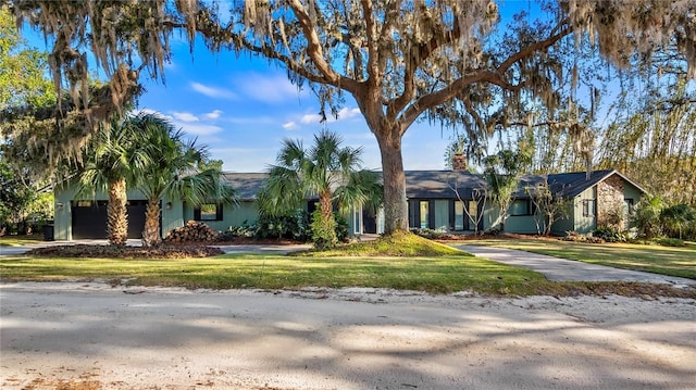 single story home with a garage and a front lawn