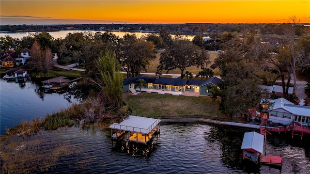 aerial view at dusk featuring a water view