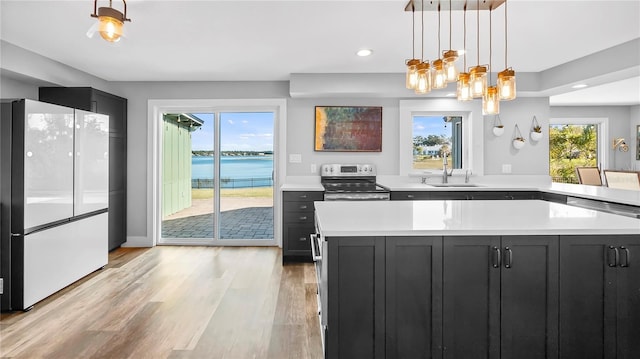 kitchen featuring electric stove, plenty of natural light, a water view, and white fridge