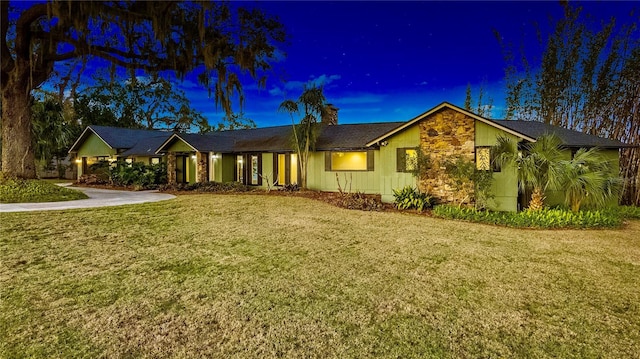 single story home with a lawn