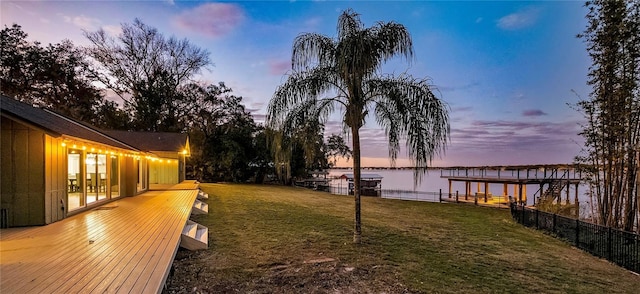 yard at dusk featuring a water view