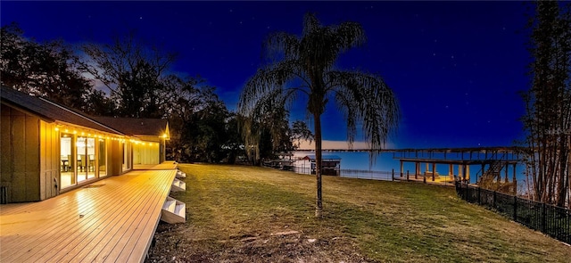 yard at dusk featuring a water view