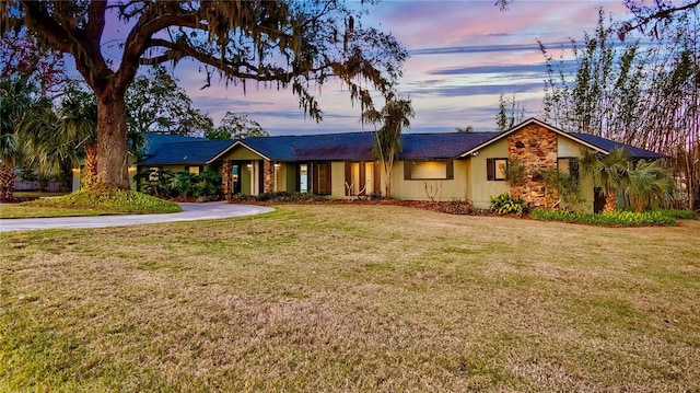 ranch-style home featuring a lawn