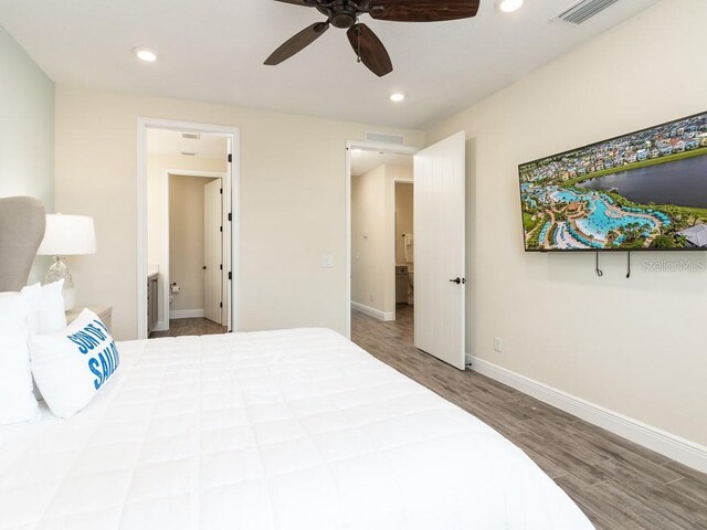 bedroom with hardwood / wood-style flooring, ceiling fan, and ensuite bath