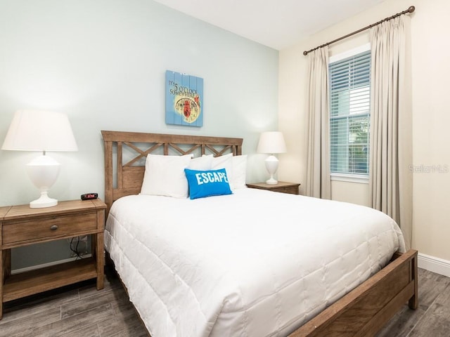 bedroom with dark hardwood / wood-style flooring