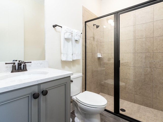 bathroom with vanity, hardwood / wood-style flooring, toilet, and walk in shower