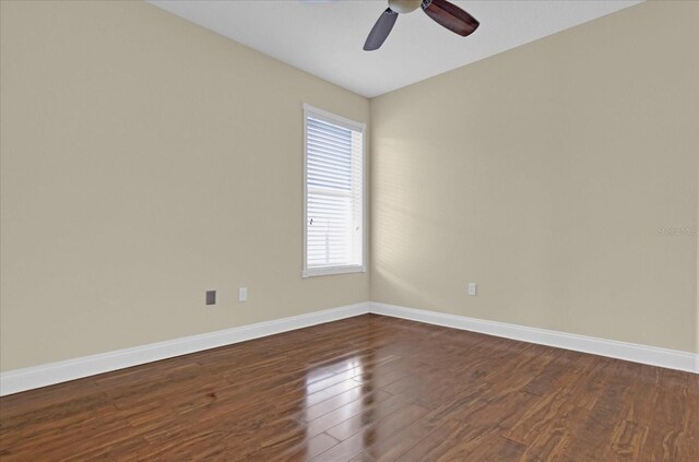 empty room with ceiling fan and dark hardwood / wood-style floors