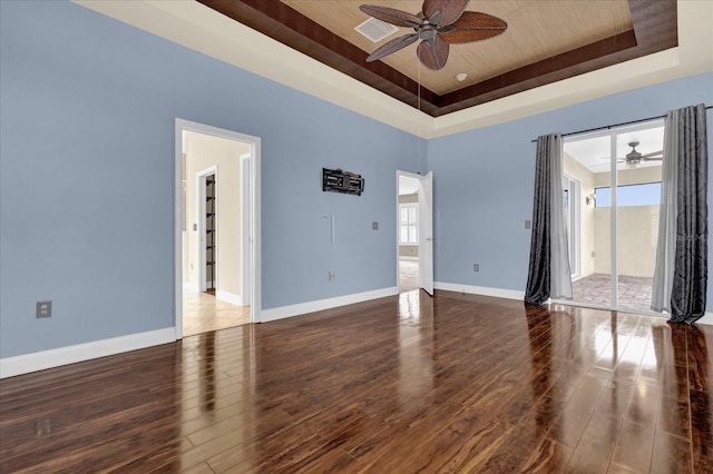 unfurnished room with a raised ceiling, ceiling fan, and hardwood / wood-style floors