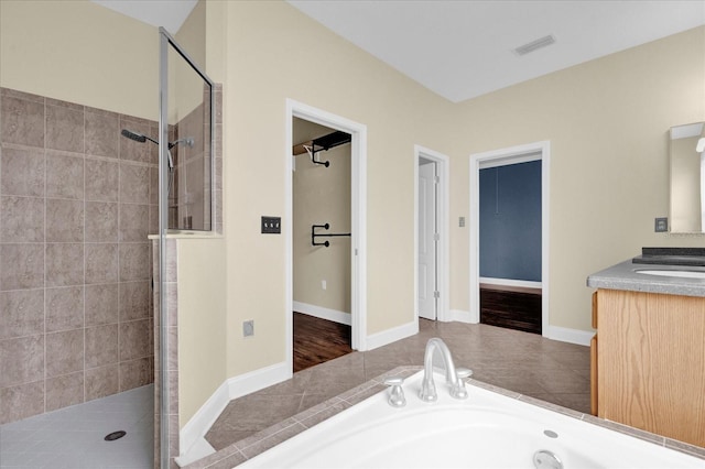 bathroom featuring vanity, hardwood / wood-style floors, and plus walk in shower