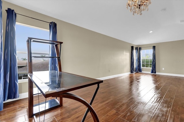 unfurnished dining area with dark hardwood / wood-style flooring and an inviting chandelier