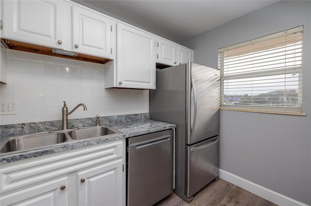 kitchen with white cabinets, sink, appliances with stainless steel finishes, tasteful backsplash, and wood-type flooring