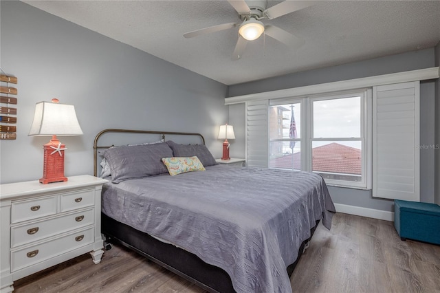 bedroom featuring ceiling fan, light hardwood / wood-style flooring, and a textured ceiling