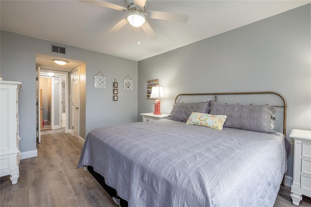 bedroom featuring hardwood / wood-style floors, a textured ceiling, and ceiling fan