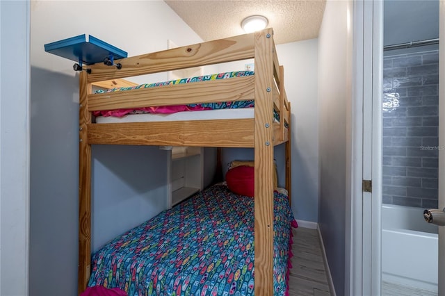 bedroom with a textured ceiling and hardwood / wood-style flooring