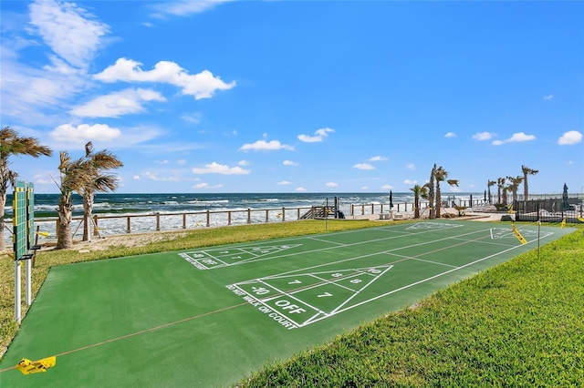 view of home's community with a view of the beach, a yard, and a water view