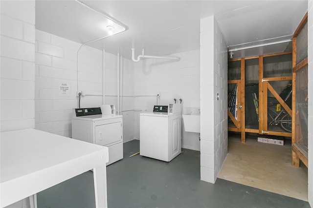 clothes washing area with washer and clothes dryer and sink