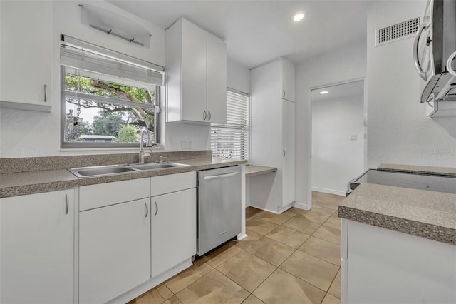 kitchen featuring dishwasher, white cabinets, light tile patterned flooring, and sink