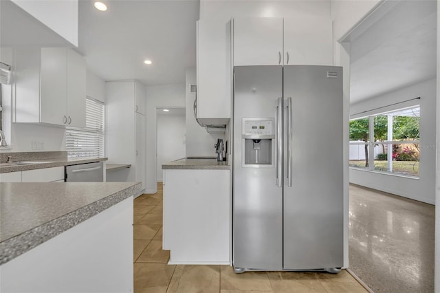 kitchen with white cabinets, light tile patterned floors, stainless steel appliances, and sink