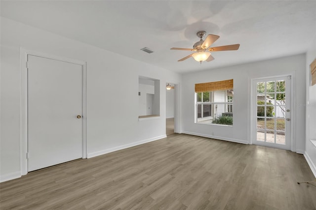 empty room with ceiling fan and light hardwood / wood-style floors