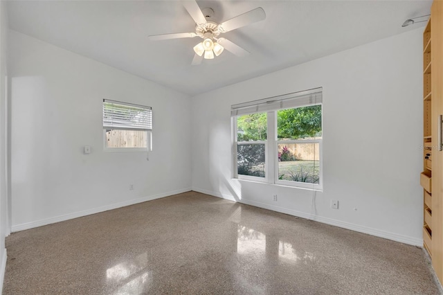 empty room featuring a wealth of natural light and ceiling fan