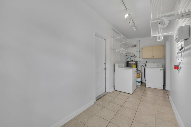 laundry area with washing machine and dryer, light tile patterned flooring, and cabinets